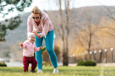 Çocuk günü konsepti. Bir anne ve bebeği parkta birlikte oynuyorlar. Açık hava eğlencesi.
