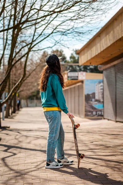 Mladá Bělošská Hipsterka Pózuje Skateboardem Odvrácenou Tváří Pozadí Uličce Koncept — Stock fotografie