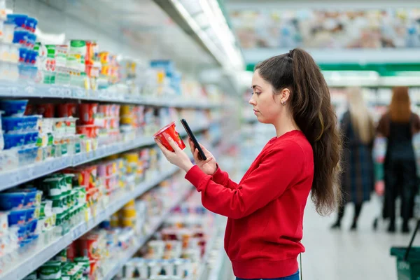 Potret Wanita Muda Memindai Kode Pada Paket Yogurt Latar Belakang — Stok Foto