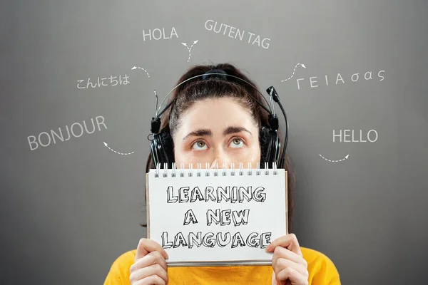 Portrait Young Woman Wearing Headphones Holding Notebook Looking Foreign Greeting — Stock Photo, Image