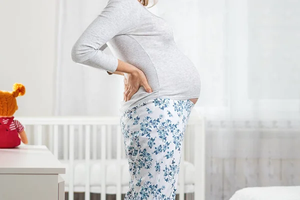 Egy Fiatal Terhes Nőnek Fáj Háta Gyerekszoba Háttérben Fogalom Terhes — Stock Fotó