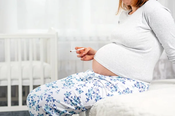 Schwangere Mit Einer Zigarette Der Hand Auf Dem Bett Sitzend — Stockfoto