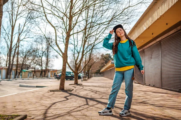 Una Joven Hipster Caucásica Sonríe Aferra Gorra Posando Con Monopatín — Foto de Stock