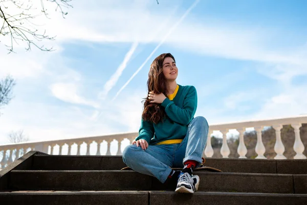 Una Hermosa Adolescente Caucásica Sentada Monopatín Mirando Distancia Fondo Cielo — Foto de Stock