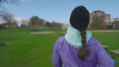 Parkta koşmak. Şapkalı genç bir kadın koşuyor. Arka plan, yakın plan. Atışı izle. Spor Yaşam Tarzı Konsepti.