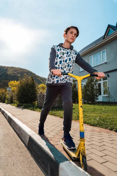 Ein Halbwüchsiger Junge Mit Ernstem Gesicht Fährt Mit Einem Roller — Stockfoto