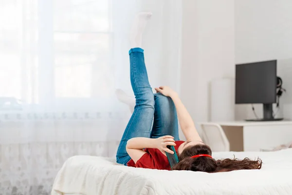 Een Jonge Vrouw Ligt Bed Haar Rug Kletst Aan Telefoon — Stockfoto