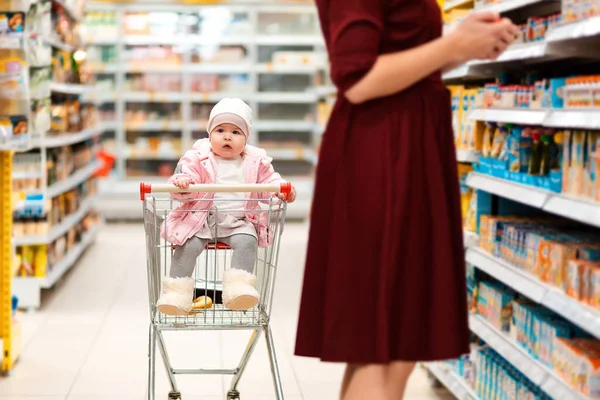 Compras Niño Pequeño Sienta Carrito Comestibles Mira Alrededor Mientras Madre —  Fotos de Stock