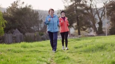 Büyükannem ve torunum birlikte koşuyorlar. Ağır çekim. Uluslararası Yaşlılar Günü 'nde. Sağlıklı yaşam tarzı ve spor kavramı.