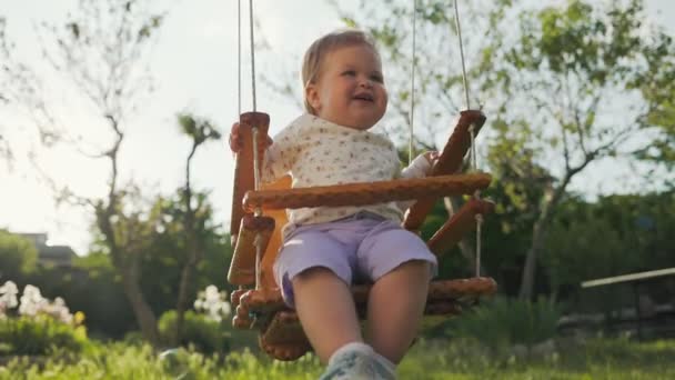 Очаровательная Малышка Развлекается Качелях Смотрит Летящие Мыльные Пузыри Вид Снизу — стоковое видео