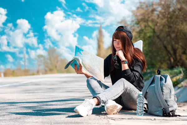 Anhalter Hipstermädchen Mit Mütze Sitzen Straßenrand Und Halten Eine Landkarte — Stockfoto