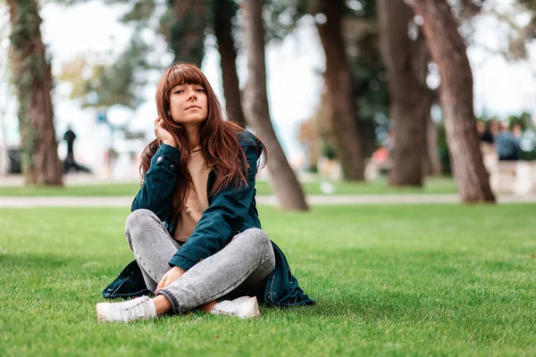 公園でのレクリエーション リラックスした女の子のクロス座って 草の上に足 スペースのコピー — ストック写真