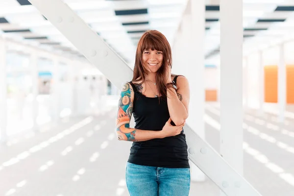 Nuori Onnellinen Nainen Jolla Tatuoinnit Käsivarressaan Poseeraa Seisoo Lähellä Valkoista — kuvapankkivalokuva