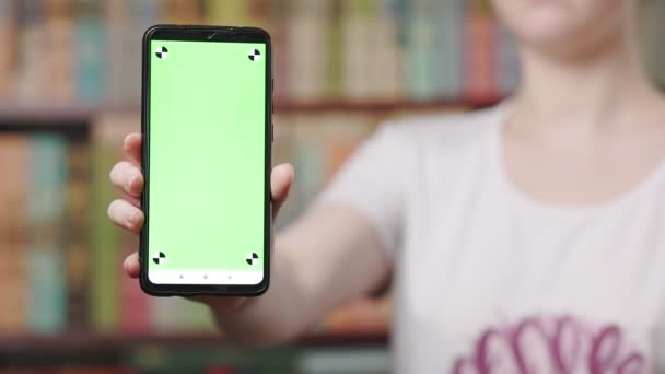 这个女人展示了一个手持绿色屏幕的智能手机 把手机放在一边 然后输入 电话和网上购物应用的概念 — 图库视频影像
