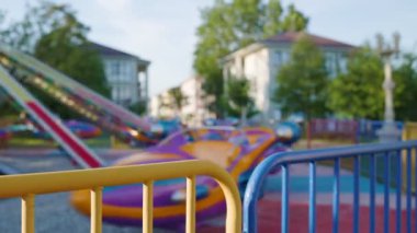 Eğlence parkı. Çok renkli bir atlı karınca dönüyor, aileyi yuvarlıyor. Bulanık. Gerçek zamanlı. Tatil ve festival konsepti.