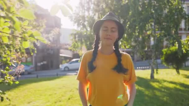 無料の千年 夏の公園を歩いている若い笑顔の女性 リアルタイムだ ドリーショット — ストック動画