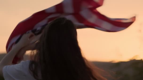 Seorang Wanita Muda Yang Bahagia Mengibarkan Bendera Amerika Berbalik Dan — Stok Video