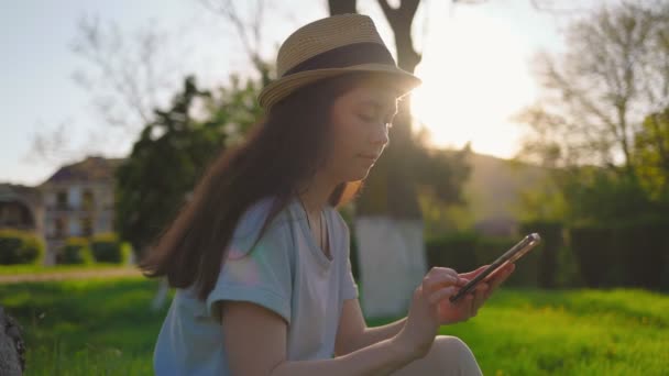 Portret Pięknej Kobiety Słomkowym Kapeluszu Wpisującej Smartfon Zachód Słońca Tle — Wideo stockowe