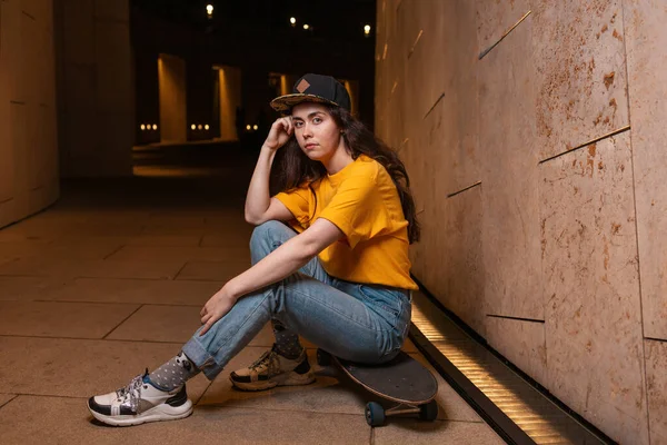 深刻な10代の女の子は 夜の通りにポーズをスケートボードに座っています 屋外だ 若者サブカルチャーの概念 — ストック写真