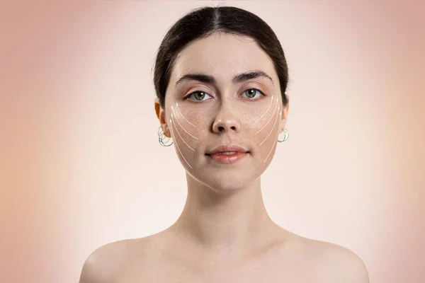 白い矢印の顔に若い美しい女性の肖像画 ベージュの背景 コピースペース 整形手術と若返りの概念 — ストック写真