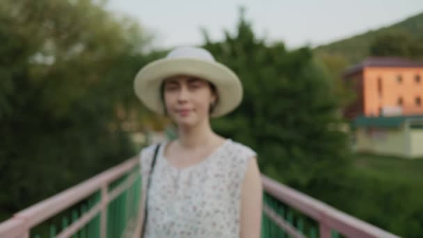 Una Donna Sorridente Con Cappello Paglia Gira Attraversa Ponte Rallentatore — Video Stock