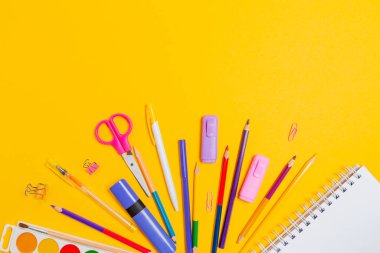 Eğitim ve iş. Sarı arka planda ofis malzemelerinin bileşimi. Düz yatıyordu. Okula geri dönüş ve tüketim kavramı.