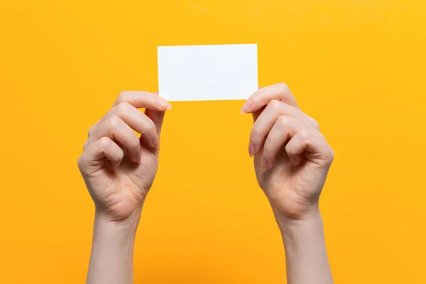 Las Manos Mujer Tienen Una Tarjeta Blanca Cerca Fondo Amarillo — Foto de Stock