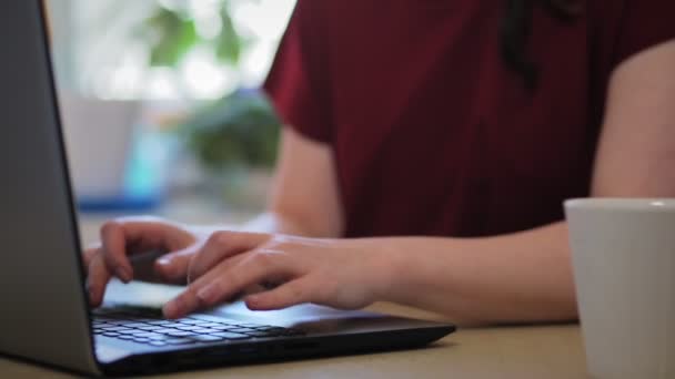 Die Frau Tippt Auf Einem Laptop Trinkt Aus Einem Becher — Stockvideo