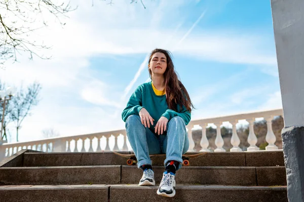 Portrét Roztomilé Kavkazské Dívky Sedící Skateboardu Pozadí Modrá Obloha Bulvár — Stock fotografie