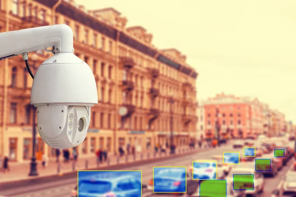 The concept of video surveillance and security technologies. Surveillance camera on the background of the city road with cars. Definition area. Tint.
