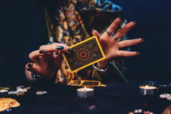 Fortune-telling on cards. Witches hands holding a Tarot card. Concept of astrology and esotericism.