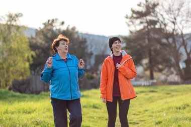Mutlu büyükanne ve torun bahar parkında birlikte yürürler. Aileyle zaman geçirmek. Uluslararası Yaşlılar Günü.