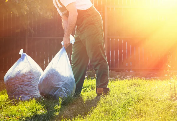 Primer Plano Jardinero Uniforme Verde Recogida Compost Bolsas Atardecer — Foto de Stock