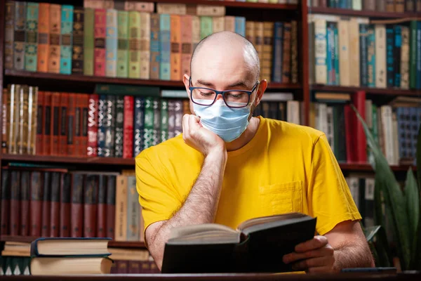 Vírus Egy Kopasz Férfi Szemüvegben Orvosi Maszkban Könyvet Olvas Háttérben — Stock Fotó
