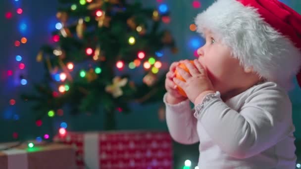 Wigilia Portret Białej Dziewczynki Świątecznym Kapeluszu Jedzącej Mandarynkę Widok Boku — Wideo stockowe