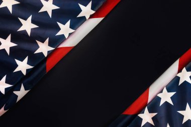 ABD 'nin ulusal bayramları. Amerikan bayrağı taşıyan siyah bir arkaplan. Düz yatıyordu. Uzayı kopyala Gaziler Günü ve Bağımsızlık Günü kavramı.