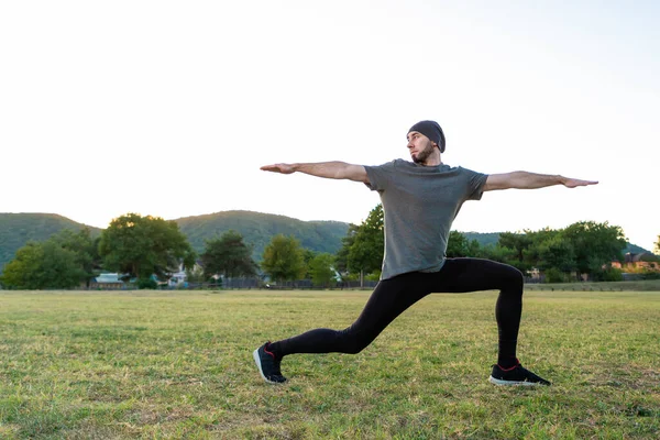 Sports and yoga. A man with a beard, in sportswear performs asana during yoga. Close up and copy space.