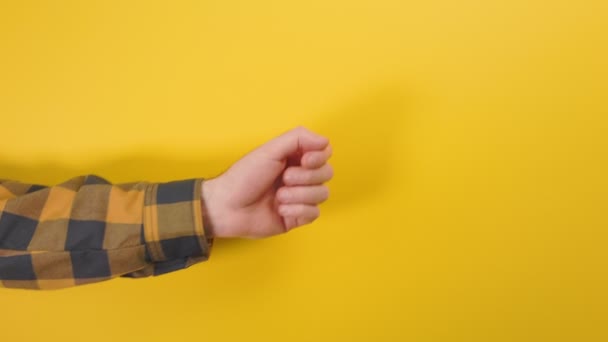 一个穿着衬衫的男人的手指示着右手食指的方向 靠近点黄色背景 — 图库视频影像
