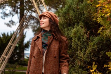 Sıcak tonlar ve yumuşak dokular, sakin bir hafta sonunun zarafetini kucaklayan sakin şehir yürüyüşü sırasında güzel bir kadını çerçeveler. Alt görünüm.