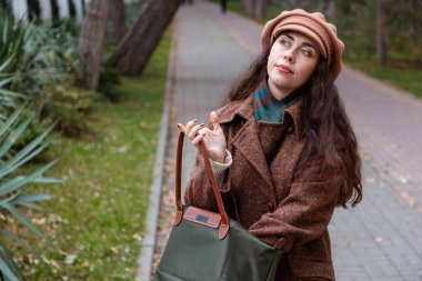 Sakin bir hafta sonu atmosferi genç bir kadını çevreledi. Sonbahar şehrinde yavaşça yürüyor, iç dünyasına odaklanmış bir şekilde.