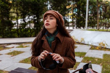 Kulaklıklı rahat bir kadın tek başına oturur ve müzik dinler. Hafta sonu öğleden sonra kendine ayıracak vakti var.