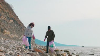 İki kadın uzak bir plajı plastik atık ve diğer atıkları toplayarak, kirliliği azaltarak ve biyolojik çeşitliliği koruyarak temizliyor. Gönüllüler çevreyi korumak için harekete geçiyor. Boşluğu kopyala.