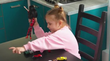 Anaokulundaki beyaz çocuk anaokulundaki bir masada oyuncak ve bebekleri keşfediyor. Oyun iyi motor becerileri, yaratıcılığı ve erken eğitim gelişimini destekler. Üst görünüm