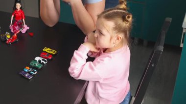 Anaokulundaki beyaz çocuğun orta fotoğrafı, Montessori sınıfındaki bir öğretmenle bir masada bebekleri keşfediyor. Etkileşimli öğrenme problem çözme, motor beceriler ve erken eğitim büyümesini teşvik eder.