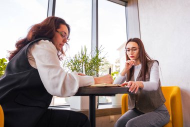 Girişimleri için haftalık hedeflerini belirleyen genç kadınlar ilham verici bir kafe oturumu, takım çalışması ve dolandırıcılık konsepti sırasında. Alt görünüm.