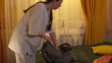 Genç Kafkasyalı kadın seyahat etmeden önce giysileri katlayarak eşyalarını düzenliyor. Kapat..