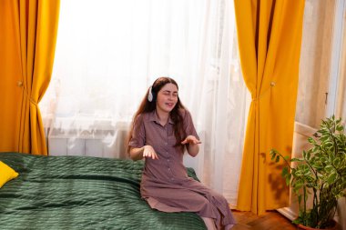 Kulaklıklı gülümseyen kadın derin müzik mutluluğu yaşıyor. Orta çekim.