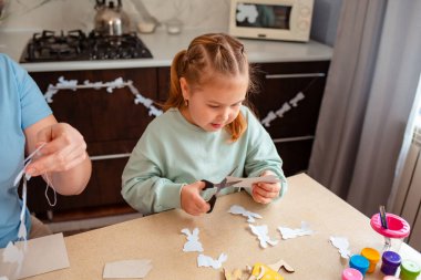 Mutfak süslemeleri yapmak için beyaz küçük kız tavşanları kesmiş. Bahar Paskalya tatili.