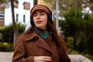 Sonbahar sezonunda, rahatlatıcı bir tek başına gezintiye çıkıp müzik dinleyen şık bir genç kadının olduğu sıradan şehir hayatı sahnesi.