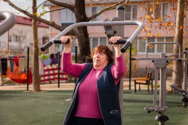 Kamu parkında açık havada spor yapan son sınıf beyaz kadın. Aktif emeklilik, sağlıklı yaşlanma ve uzun yaşam tarzı.